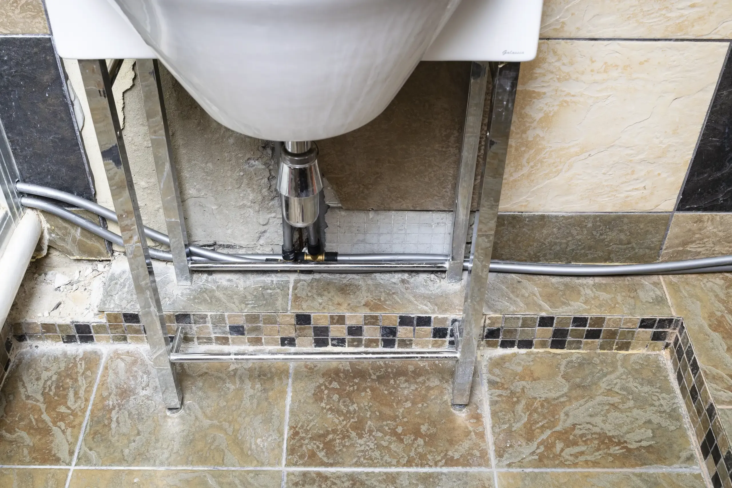 Sicht auf den Waschbeckenunterschrank mit Wasserinstallation im Badezimmer