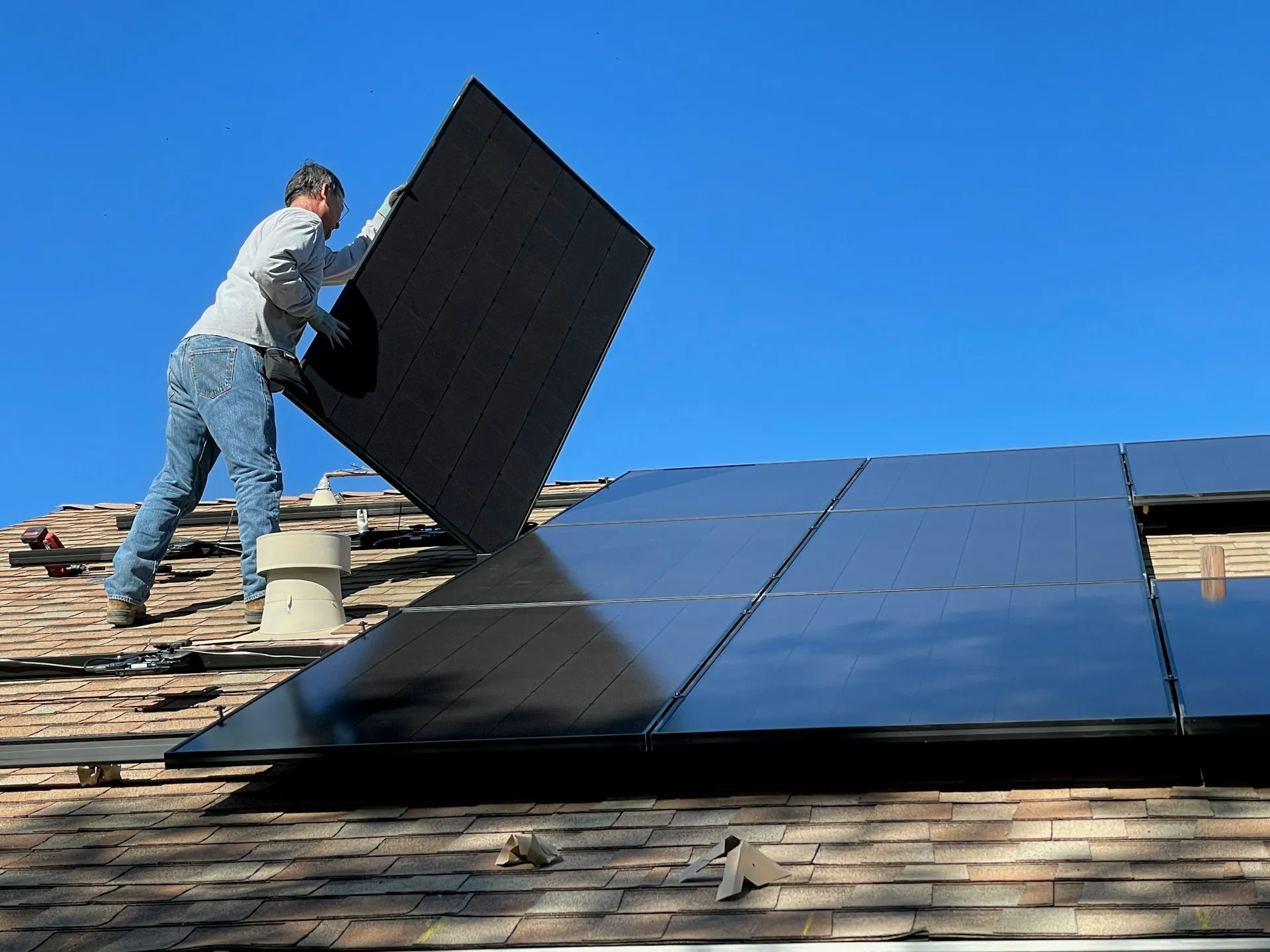 Ein Handwerker installiert Solaranlagen auf einem Dach